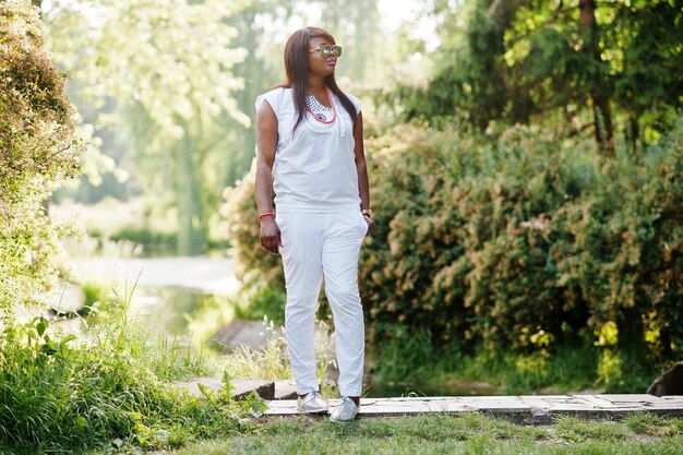 Afrikanische Frau in nationaler weißer Kleidung und Sonnenbrille
