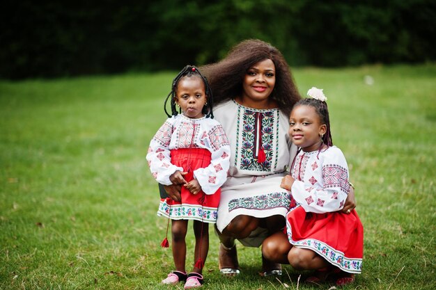 Afrikanische Mutter mit Töchtern in traditioneller Kleidung im Park