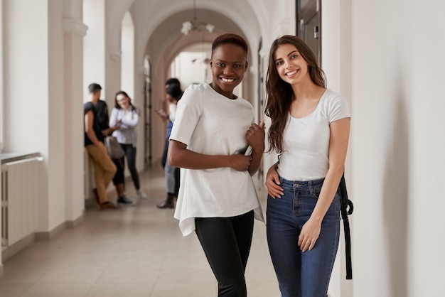 Kostenloses Foto afrikanische und kaukasische mädchen auf dem korridor der universität