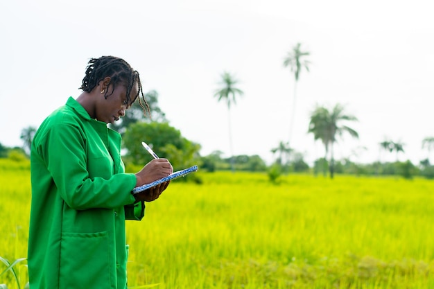 Afrikanischer Bauer, der Notizen auf einer Farm macht