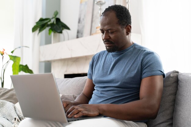 Afrikanischer Mann, der von zu Hause aus arbeitet