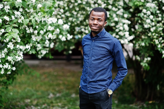 Afrikanischer Mann posierte auf der Straße der Stadtkleidung auf blauem Hemd und schwarzer Hose