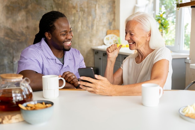 Afrikanischer Sozialarbeiter, der einer älteren Frau hilft