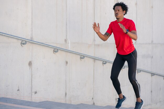 Afro athletischer Mann, der Übung draußen an der Treppe tut. Sport und gesunder Lebensstil.