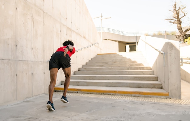 Afro athletischer Mann, der im Freien läuft und Übung macht