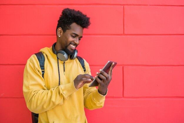 Afro Mann mit seinem digitalen Tablet mit Kopfhörern.