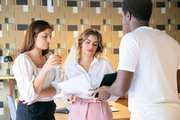 Afroamerikaner Mann, der Tablettbildschirm zu Partnern zeigt