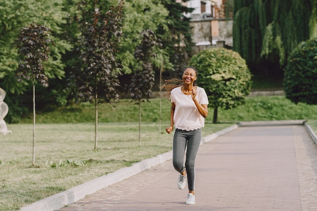 Afroamerikanerfrau, die Training im Park in Sportbekleidung hat