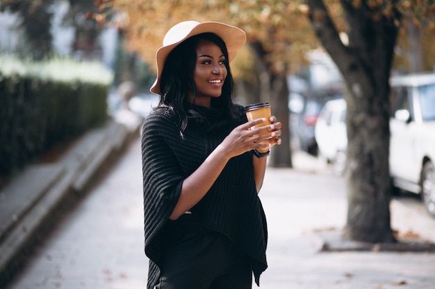 Afroamerikanerfrau in trinkendem Kaffee des Hutes