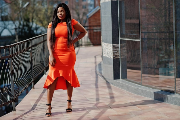 Afroamerikanerfrauenmodell xxl im orangefarbenen Kleid