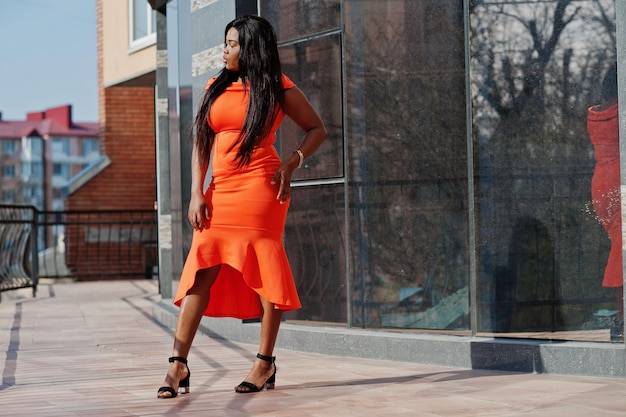 Afroamerikanerfrauenmodell xxl im orangefarbenen Kleid