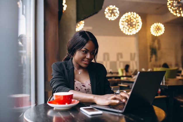 AfroamerikanerGeschäftsfrau, die in einem Café arbeitet