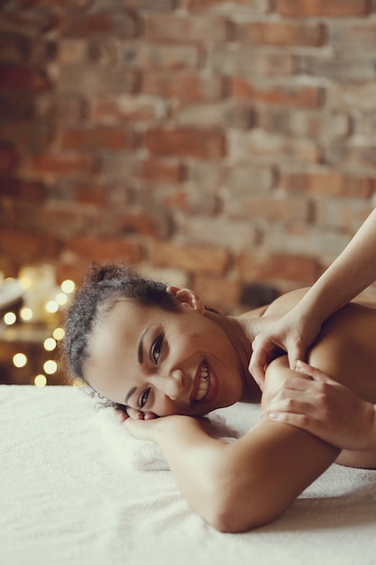 Afroamerikanerin, die eine entspannende Massage am Spa erhält