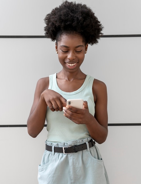 Afroamerikanerin, die jemandem auf ihrem smartphone eine sms schreibt