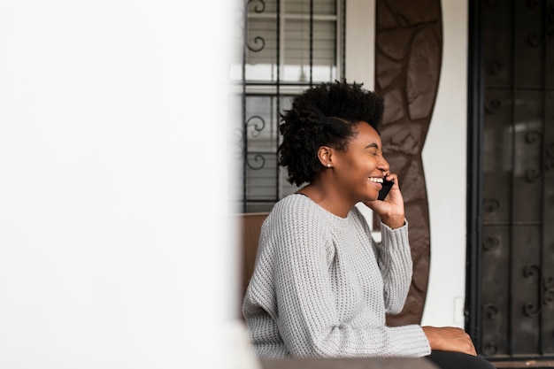 Afroamerikanerin, die während der covid 19-pandemie am telefon spricht