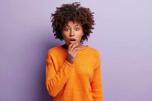 Afroamerikanerin im orangefarbenen Pullover