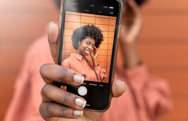 Afroamerikanerin macht ein Selfie mit ihrem Smartphone