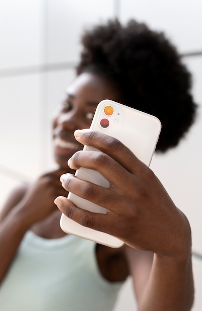 Afroamerikanerin macht ein Selfie mit ihrem Smartphone