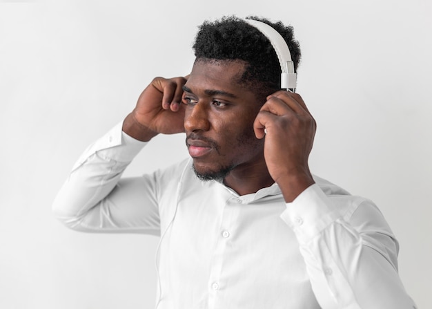 Afroamerikanermann, der Kopfhörer benutzt und wegschaut