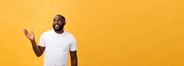 Afroamerikanermann mit dem Bart, der die Handabwesende Seite lokalisiert über gelbem Hintergrund zeigt