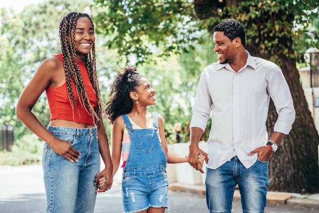 Afroamerikanische Familie, die zusammen draußen auf der Straße spazieren geht