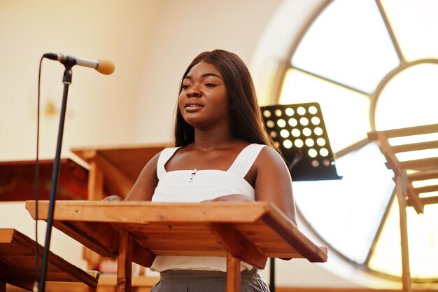 Afroamerikanische Frau, die in der Kirche betet Gläubige meditieren in der Kathedrale und in der spirituellen Gebetszeit Afro-Mädchen singen und verherrlichen Gott in Chören