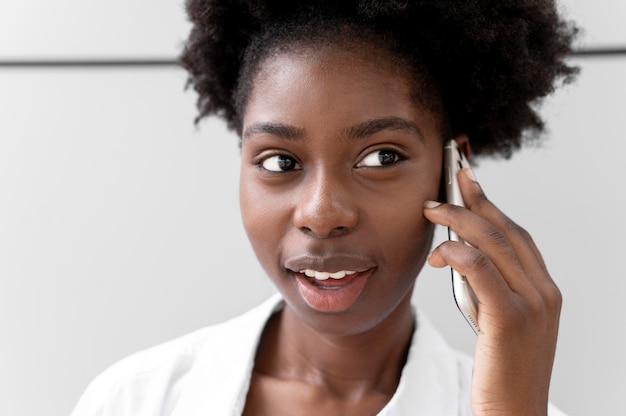 Afroamerikanische Frau, die mit jemandem auf ihrem Smartphone spricht