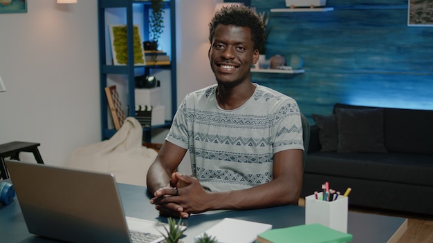 Afroamerikanischer Mann, der am Laptop lächelt und arbeitet