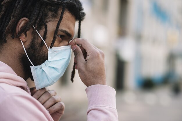 Afroamerikanischer Mann, der medizinische Maske repariert