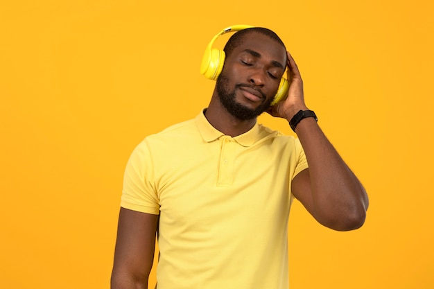 Afroamerikanischer Mann, der Musik über Kopfhörer hört