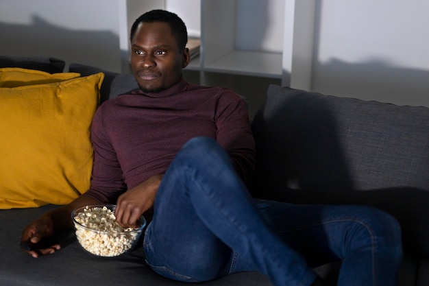 Afroamerikanischer Mann, der zu Hause einen Streaming-Dienst ansieht