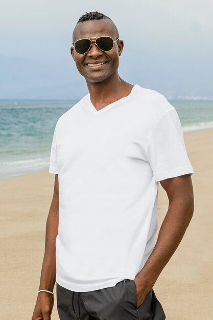 Afroamerikanischer Mann im weißen T-Shirt am Strand