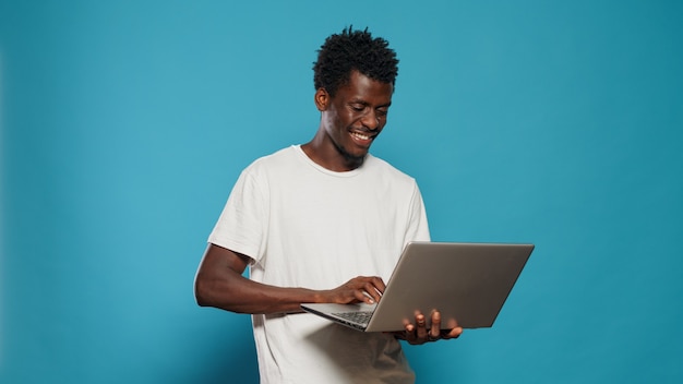 Afroamerikanischer Mann mit Laptop zur Unterhaltung