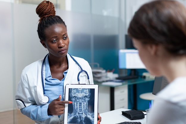 Afroamerikanischer radiologe arzt bespricht knochenradiographie