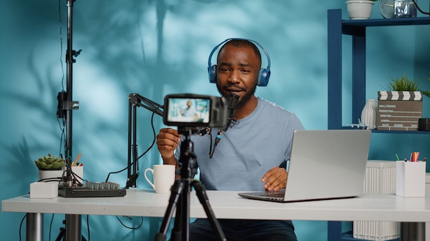 Afroamerikanischer Vlogger mit Kamera zum Aufnehmen von Videos