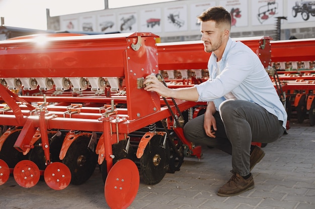 Agronom wählt einen neuen Pflanzer. Mann am Außengrund des Ladens. Landwirtschaftliche Maschinen.