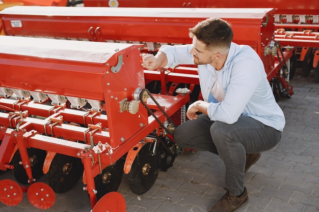 Agronom wählt einen neuen Pflanzer. Mann am Außengrund des Ladens. Landwirtschaftliche Maschinen.