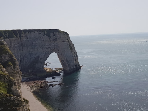 Kostenloses Foto aiguille d'etretat, umgeben vom meer unter dem sonnenlicht in frankreich