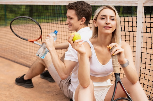 Aktive tennispaare, die eine pause machen