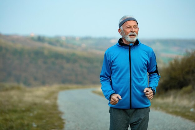 Aktiver Seniorensportler mit gesundem Lebensstil und Joggen in der Natur Kopierraum