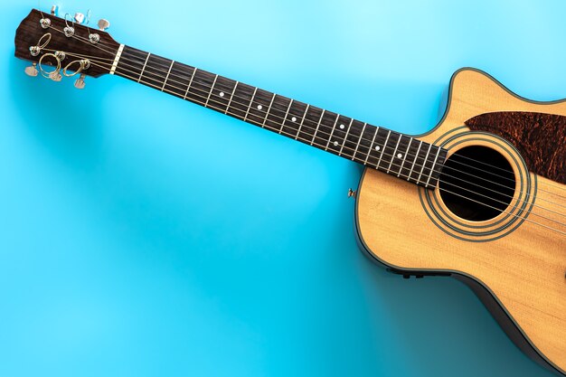 Akustikgitarre auf einem blauen Hintergrund Draufsicht Kopienraum