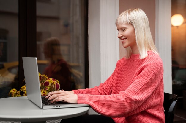 Albino-Frau mit mittlerem Schuss, die mit Laptop arbeitet