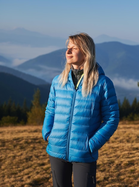 Allein blondes Mädchen, das in die Berge geht