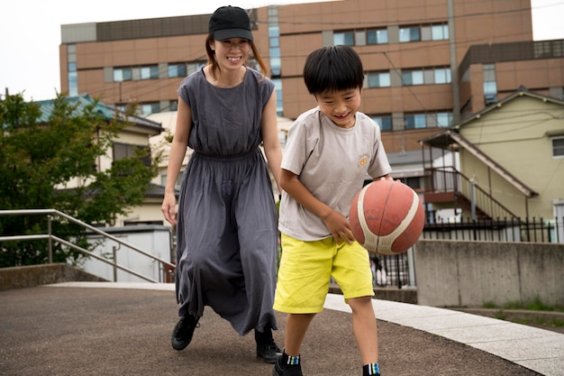Kostenloses Foto alleinerziehende mutter spielt basketball mit ihrem sohn