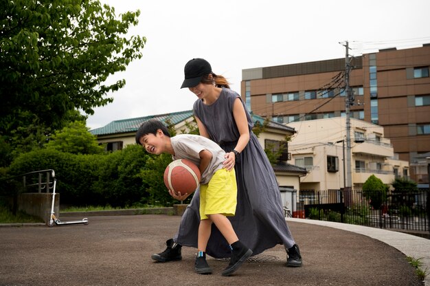 Kostenloses Foto alleinerziehende mutter spielt basketball mit ihrem sohn