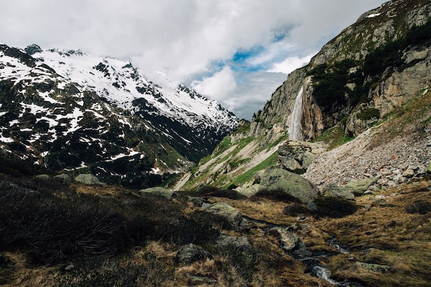 Kostenloses Foto alpine landschaft des schönen sommers mit wasserfall im berg