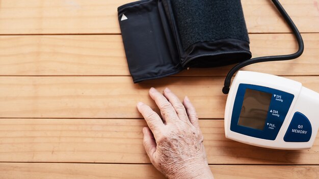 Alte Dame wird Blutdruck unter Verwendung des Blutdrucküberwachungskindersatzes überprüft