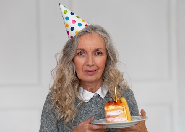 Alte Frau des mittleren Schusses, die Kuchen hält