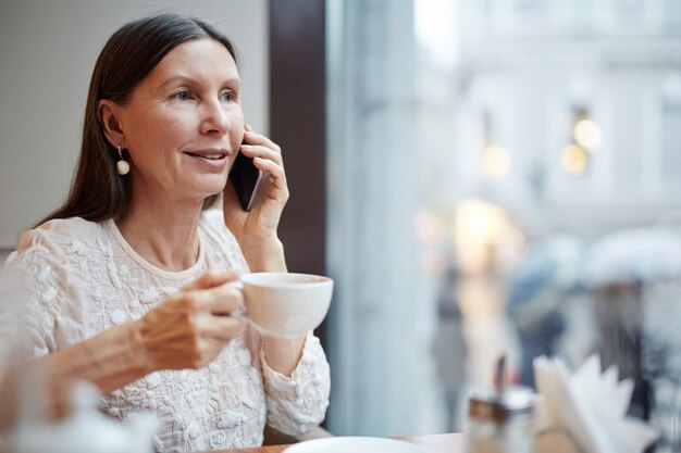 Alte Frau, die Telefon verwendet