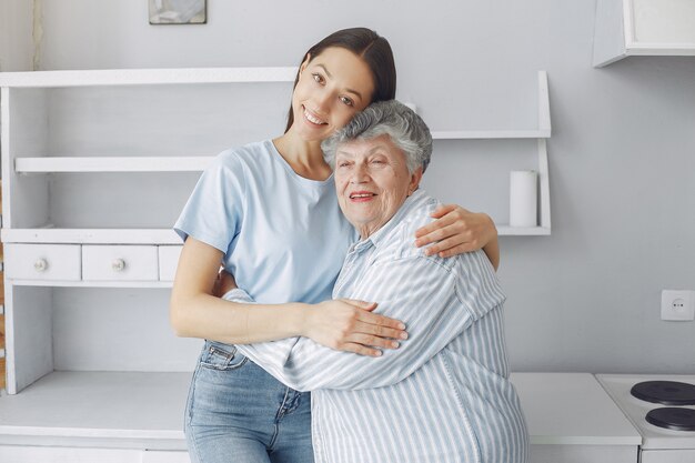 Alte Frau in einer Küche mit junger Enkelin